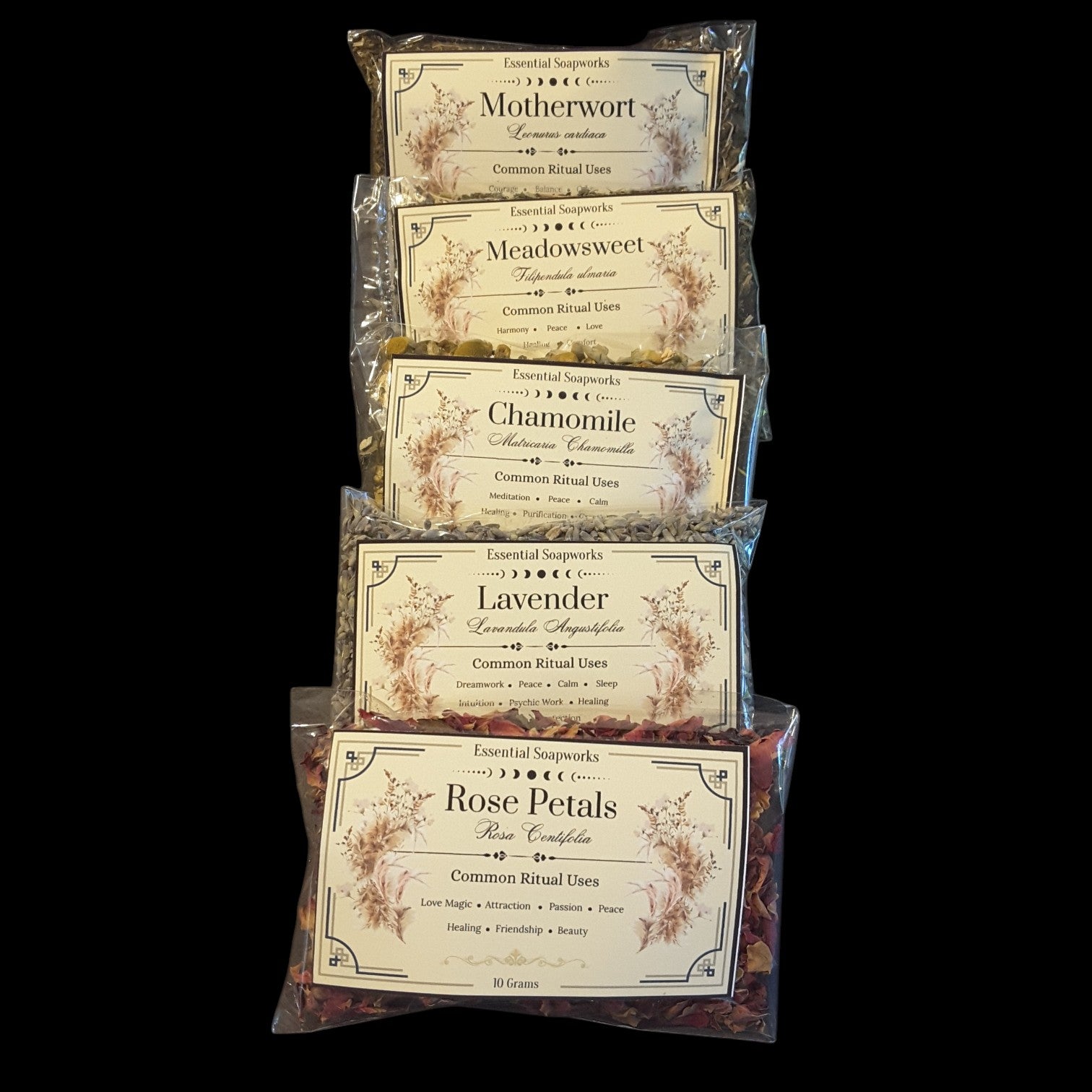 Five clear plastic bags of witchy herbs for peace and tranquility arranged in a vertical stack against a solid black background. The bags feature vintage-style cream labels with floral illustrations and text including 'Motherwort', 'Meadowsweet', 'Chamomile', 'Lavender', and 'Rose Petals'.