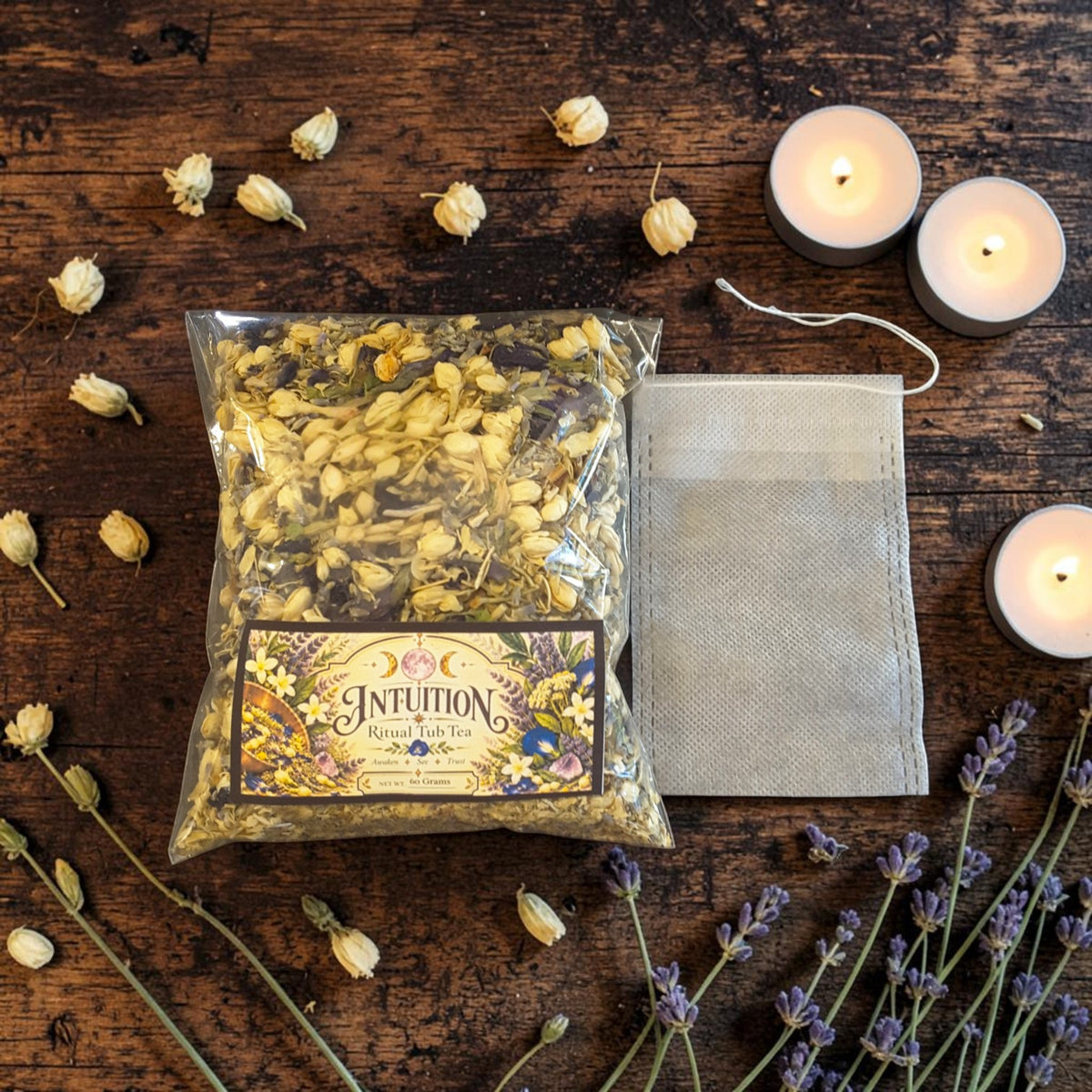 intuition tub tea on a dark wooden surface next to a muslin bag with jasmine, lavender and candles
