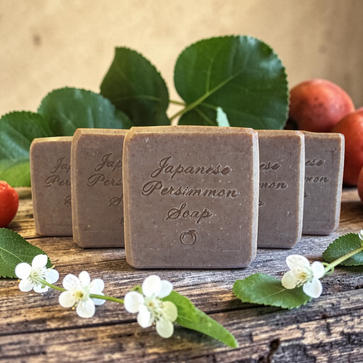Japanese Persimmon soap bars on a wooden surface with leaves and flowers.