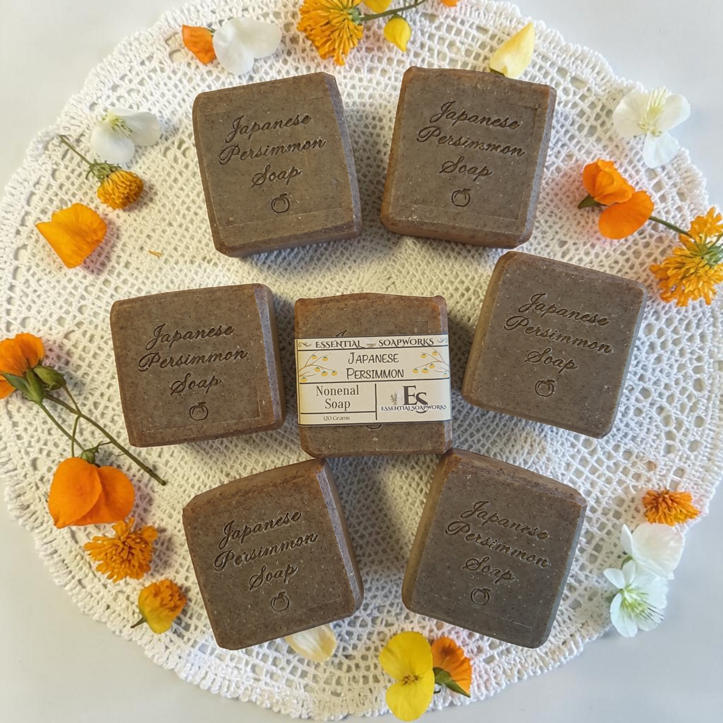 Japanese Persimmon soap bars on a textured surface with flowers around