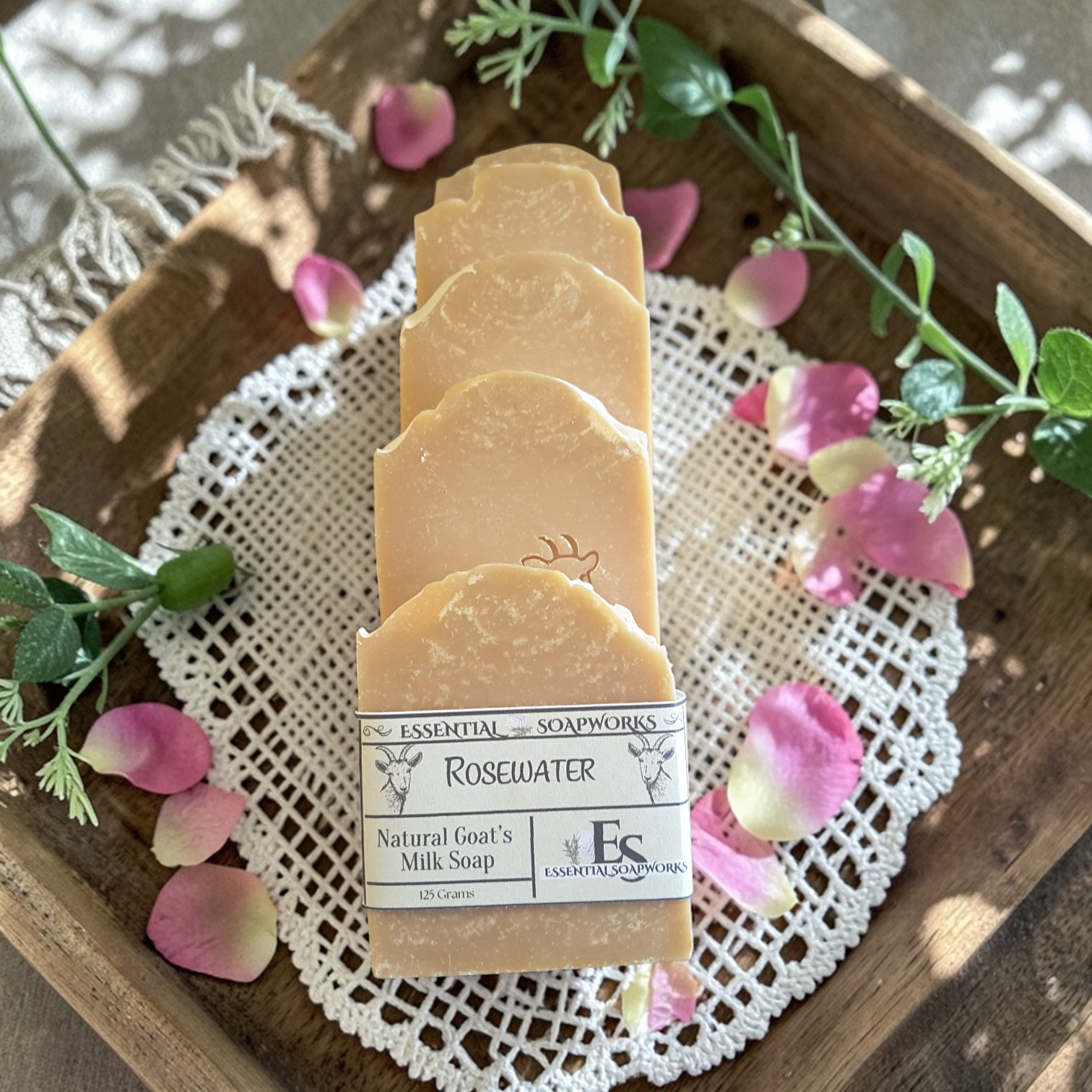 goat milk soap bars on a wooden tray with flowers