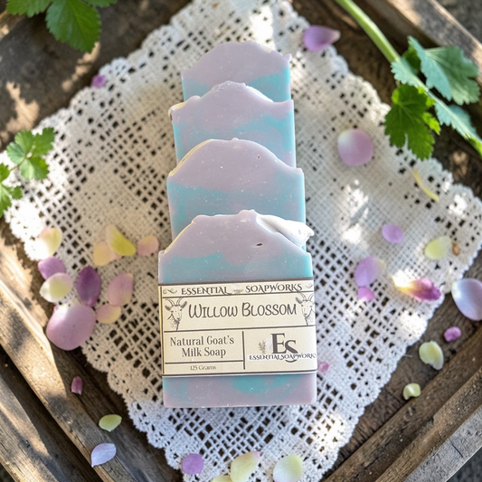 Natural goat milk soap bars on a wooden surface with lace fabric and flower petals