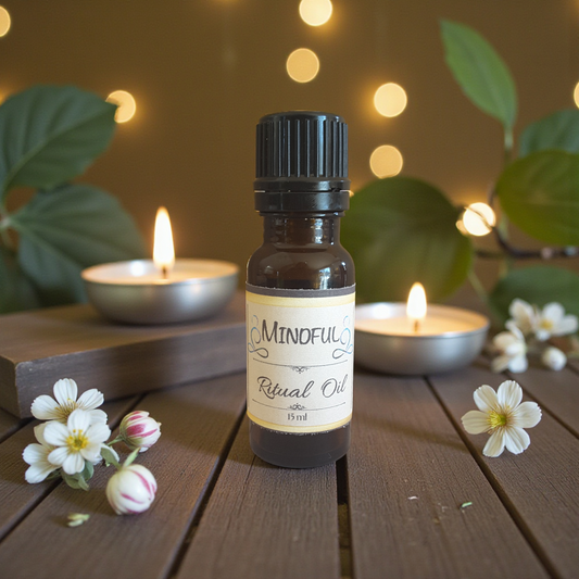 Bottle of 'Mindful Ritual Oil' on a wooden surface with candles and flowers in the background.