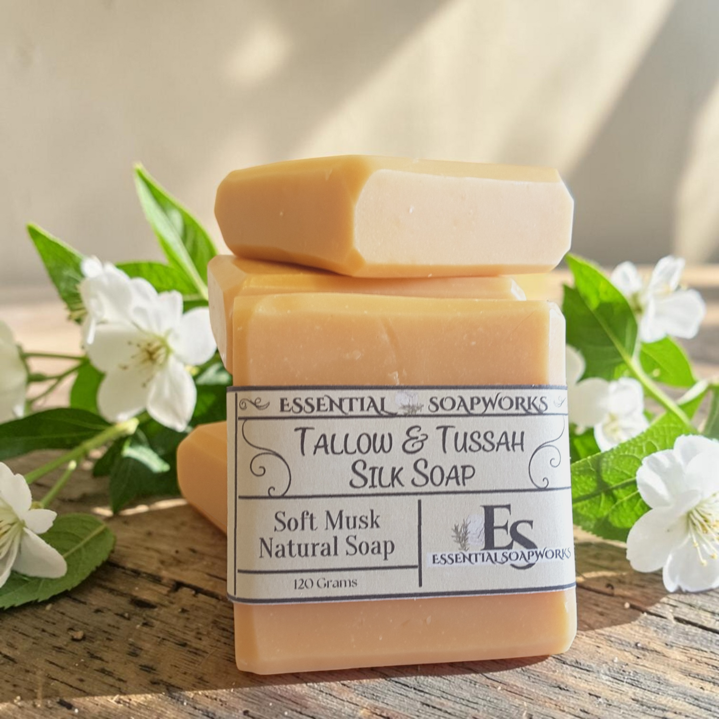 soft musk tallow soap on a wooden surface with white flowers