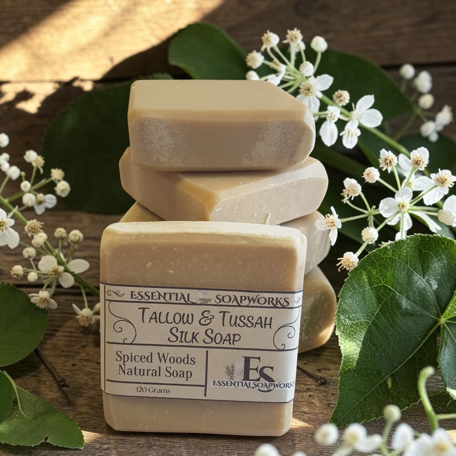 spiced woods tallow soap on a wooden surface with green leaves and white flowers
