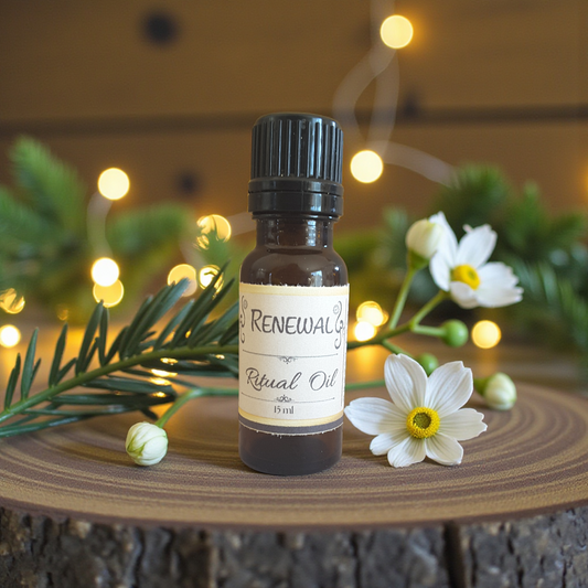 Bottle of Renewal Ritual Oil with flowers and lights on a wooden surface
