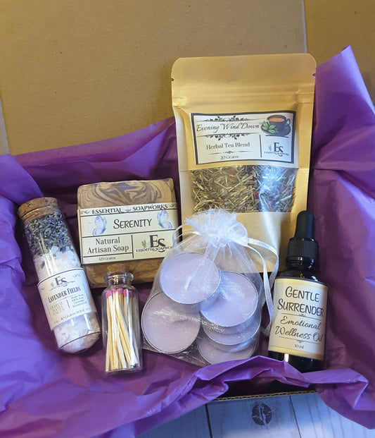 evening wind down ritual kit including soap, tea blend, essential oils, and candles in a kraft box with purple tissue paper