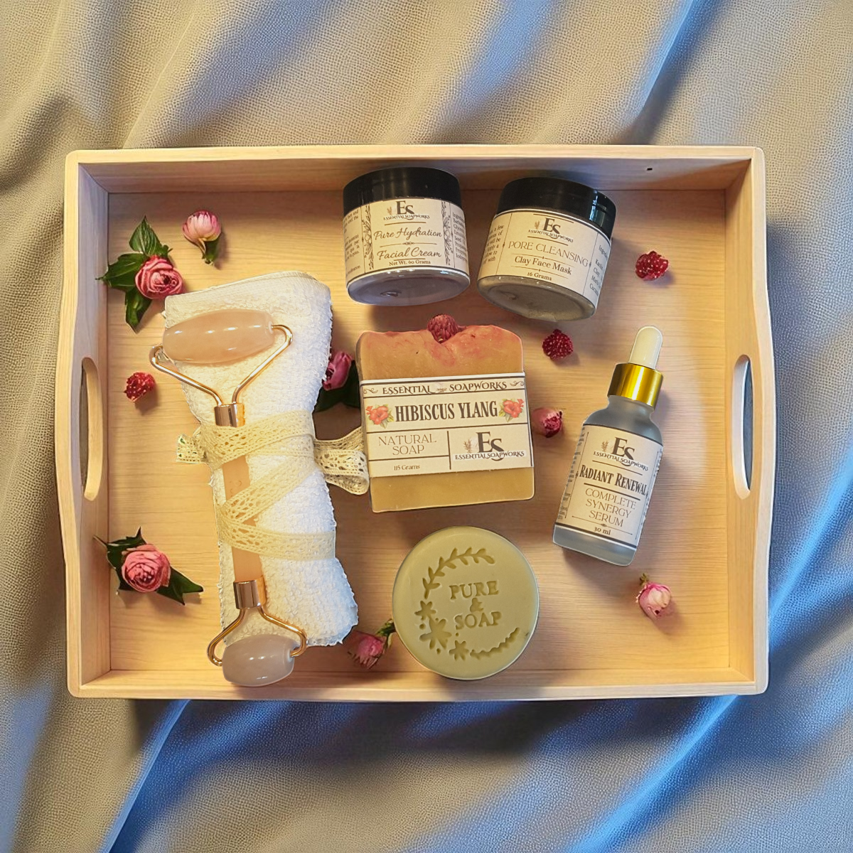 Wooden tray with skincare products and decorative elements on a fabric background