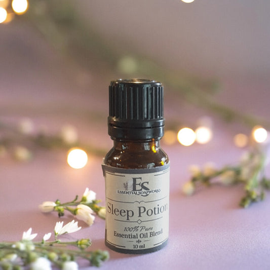 Essential oil bottle labeled 'Sleep Potion' with decorative lights and flowers in the background
