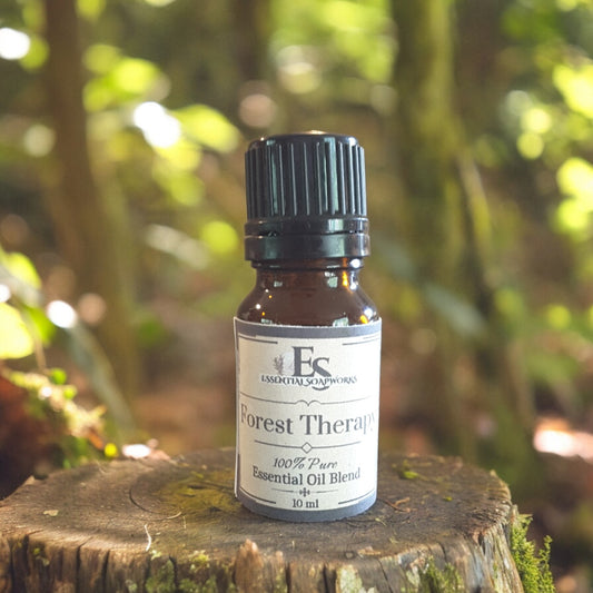 Bottle of 'Forest Therapy' essential oil diffuser blend on a wooden stump with a forest background
