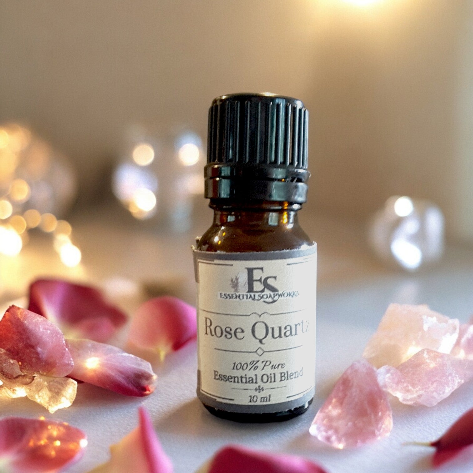 Rose Quartz essential oil diffuser blend with pink stones and petals on a soft background