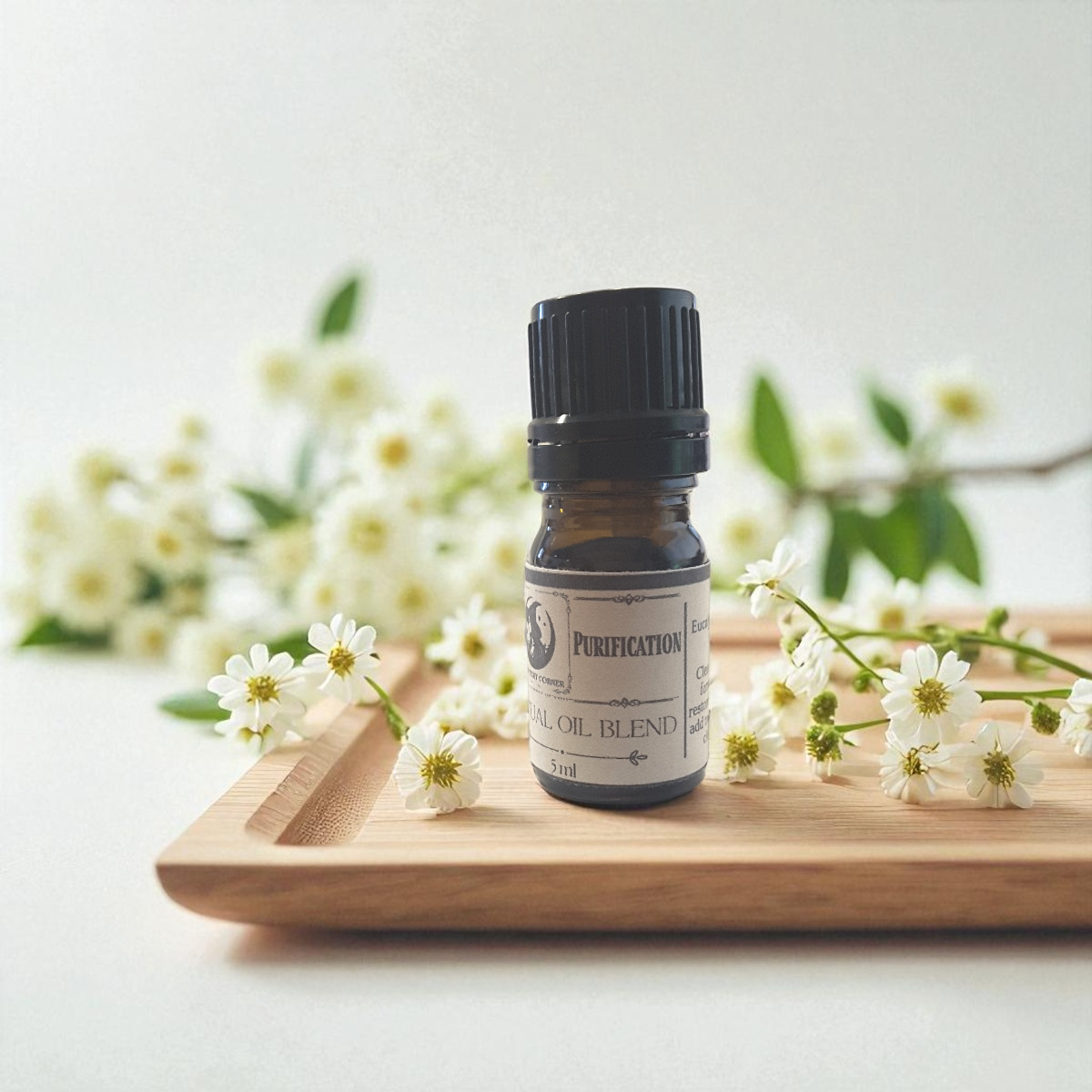 Purification ritual oil on a wooden tray with white flowers and green leaves.