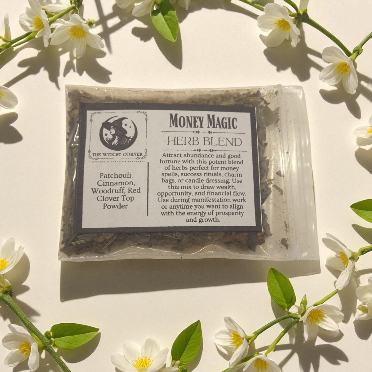 Money Magic herb blend surrounded by white flowers on a light background