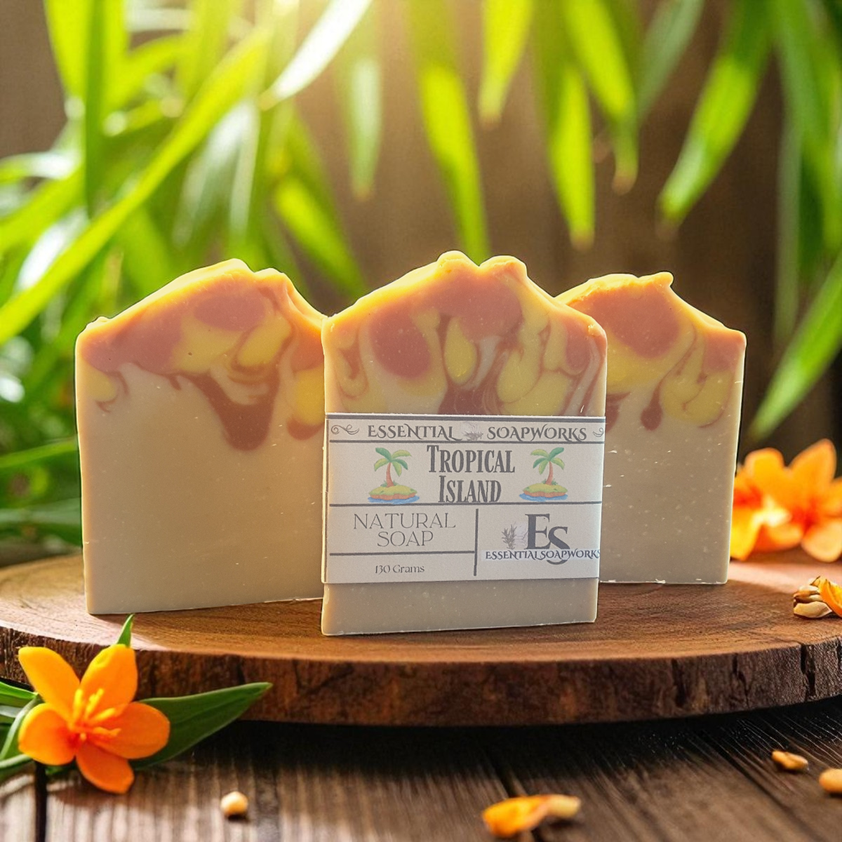 Three bars of soap with a label on a wooden surface with plants in the background